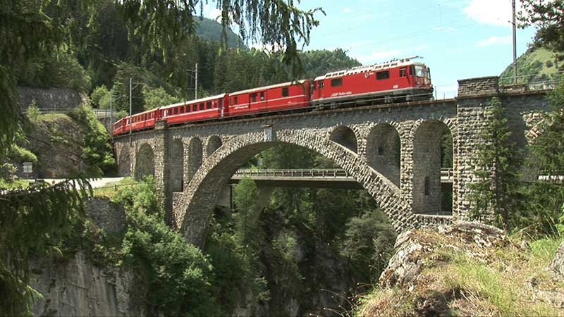 RhB-Zug fährt über eine Brücke